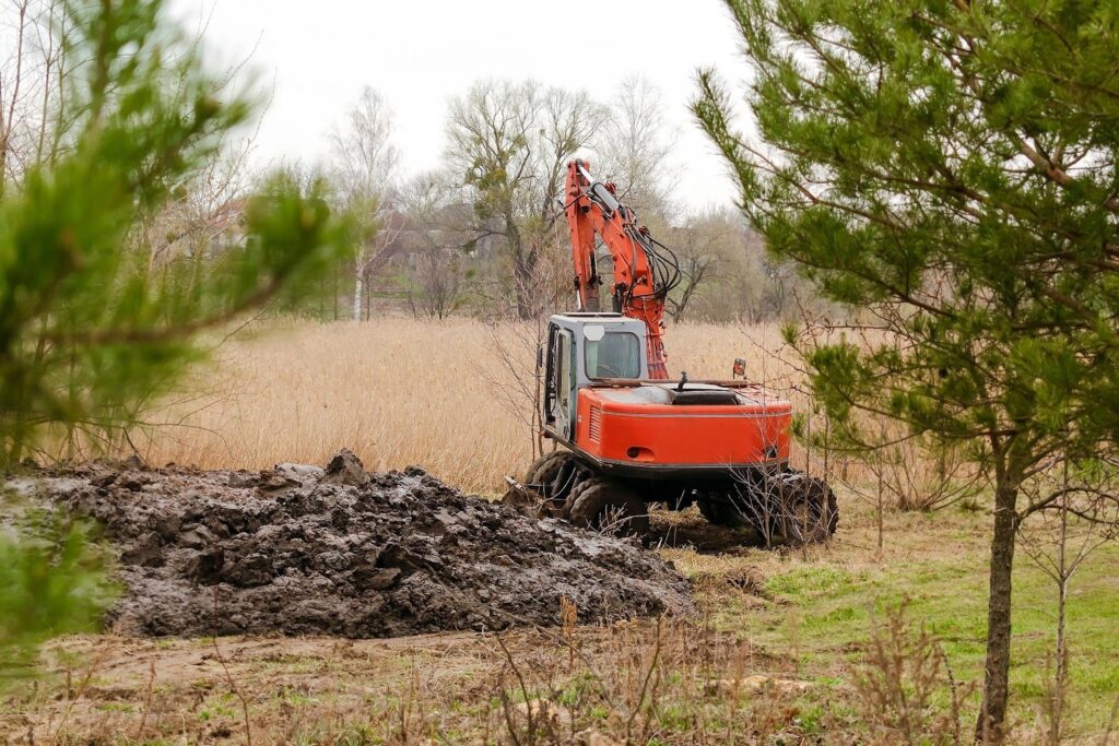 Tractor preparing agricultural land through controlled land clearing